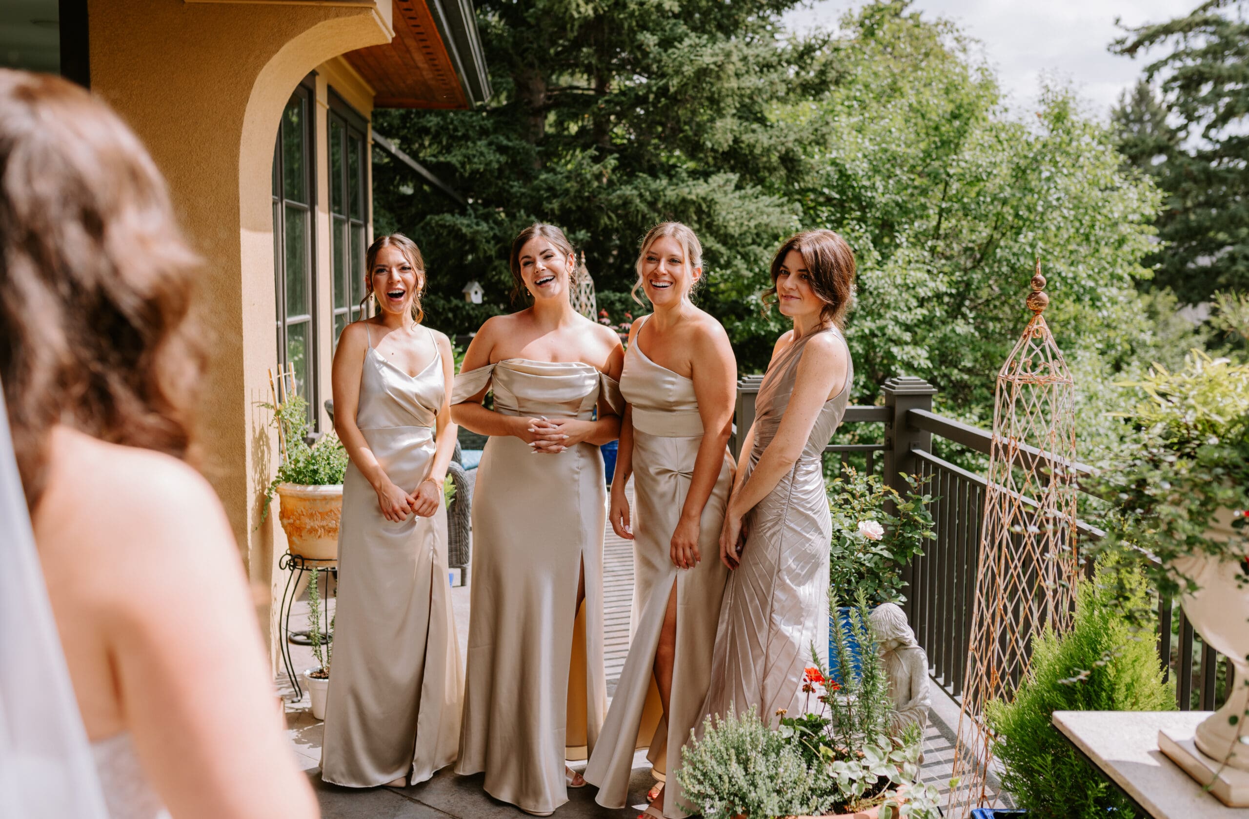 Four bridesmaids react to seeing a bride for the first time.