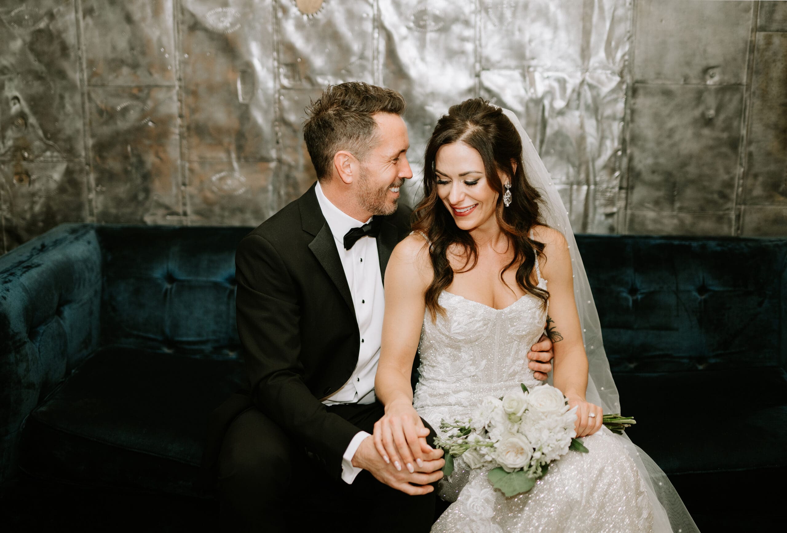 A bride and groom sit together in the Parlour Room at The Commons in Calgary, Alberta