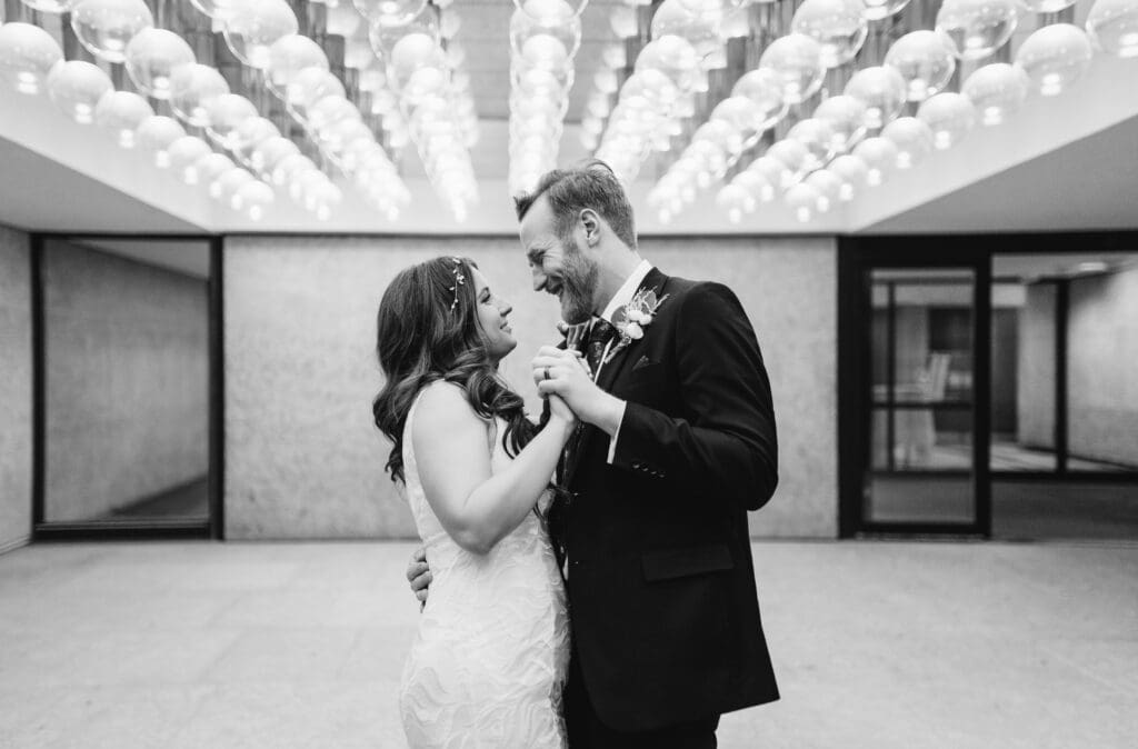 A bride and groom dance under the lights at the Winnipeg Art Gallery.