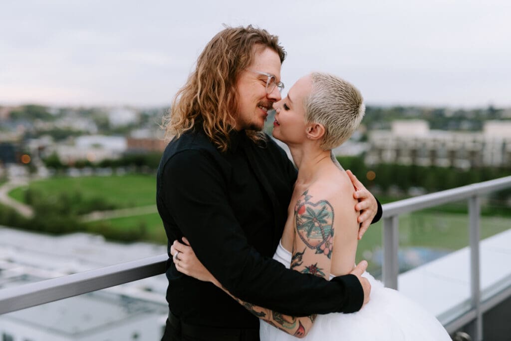 A couple poses for anniversary photos on a rooftop in downtown Calgary.