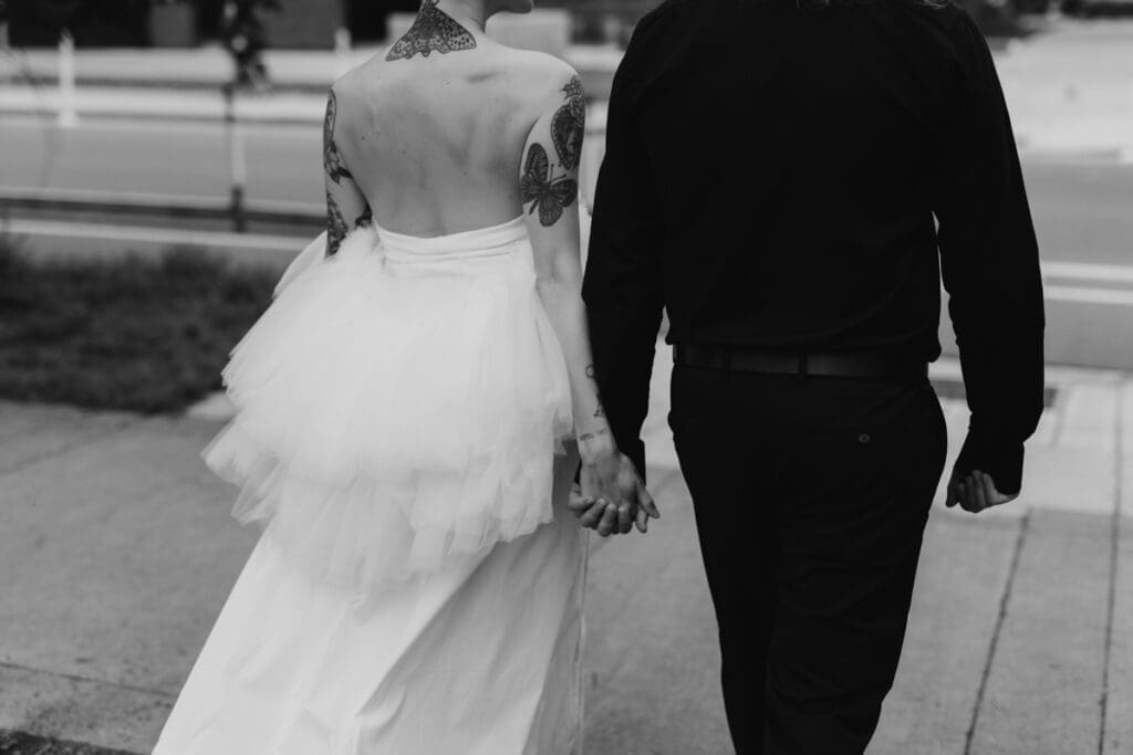 A black and white photos of a couple walking in downtown Calgary